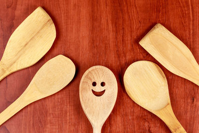 Directly above shot of wooden spoon with anthropomorphic smiley face on table