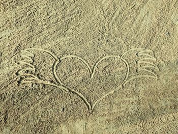 High angle view of heart shape on sand