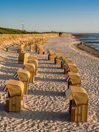 Chairs on beach against clear sky