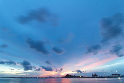 Scenic view of sea against dramatic sky during sunset