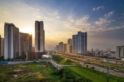 Modern buildings in city against sky during sunset