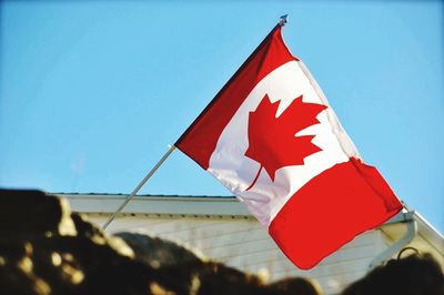 Low angle view of flag against clear blue sky