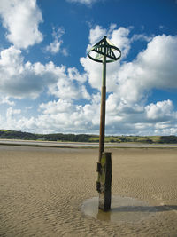 Street light on beach against sky