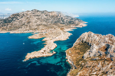 High angle view of rock formation in sea against sky