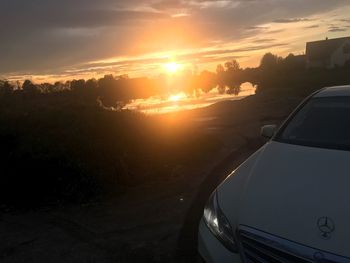 Close-up of car against sky during sunset