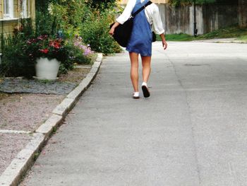 Low section of woman walking on footpath