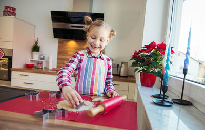 Smiling girl preparing cookies at home