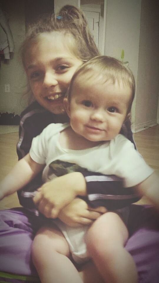 PORTRAIT OF HAPPY MOTHER AND BABY SITTING ON FLOOR