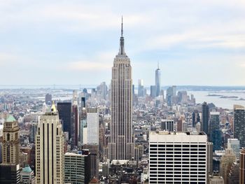 Modern buildings in city against cloudy sky