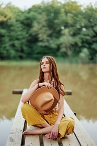 Young woman using mobile phone while sitting at park