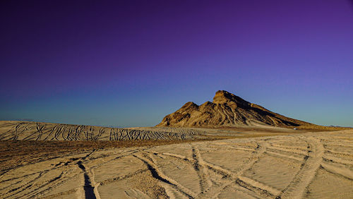 Scenic view of desert against clear blue sky