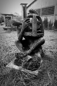 Old statue sitting on field