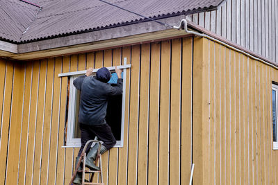 Rear view of man standing against building