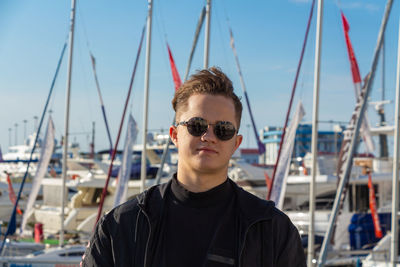 Portrait of a young guy on the background of the sea and yachts. person