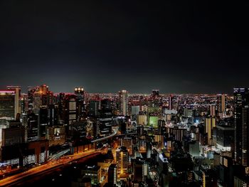 Illuminated cityscape against sky at night