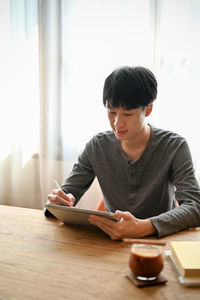 Portrait of young woman using mobile phone at home