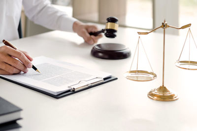 Midsection of woman reading book on table