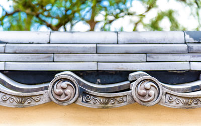 Close-up of bench against wall
