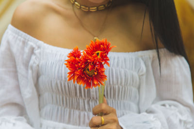 Close up portrait asian woman in a white dress with artificial flower in her hands