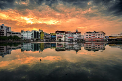 Reflection of buildings in city at sunset