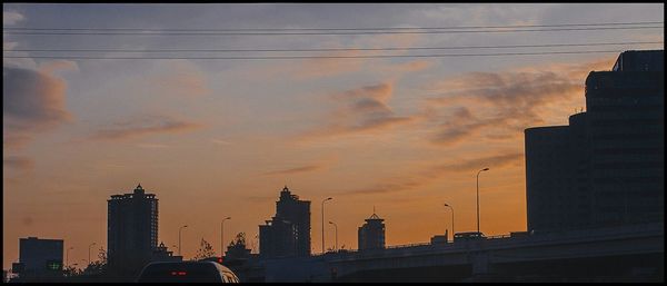 Low angle view of buildings against sky at sunset