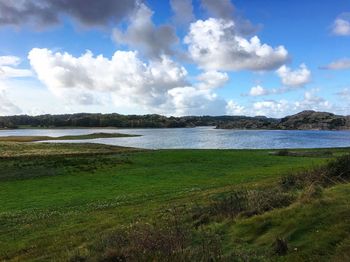 Scenic view of calm lake against cloudy sky