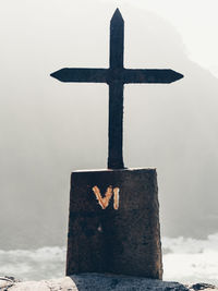 Close-up of cross against sky