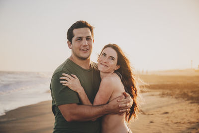 Portrait of young couple hugging on beach