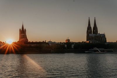 View of church at waterfront during sunset