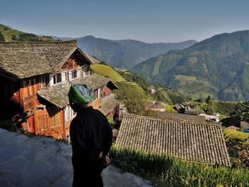 Rear view of man standing outside house