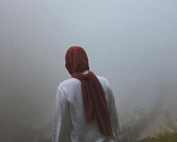 Rear view of woman standing by sculpture against sky