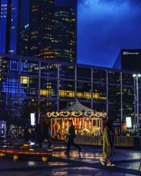 People in illuminated city at night