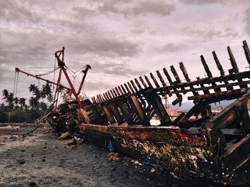 Shipwreck at beach against sky