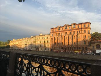 Bridge over canal by buildings in city against sky