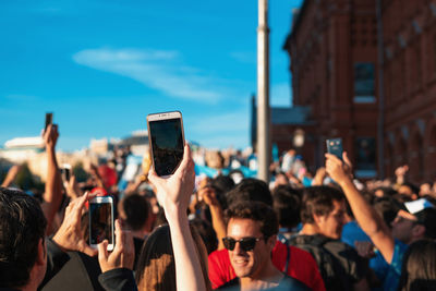 Group of people photographing at music concert in city