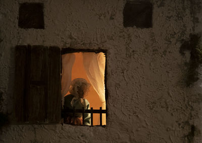 Reflection of woman on window in building