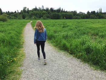 Rear view of woman walking on field