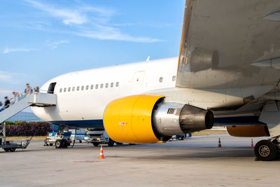 Airplane on airport runway against sky