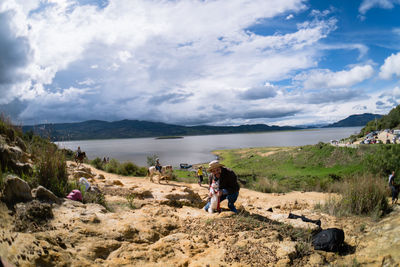 Rear view of people on mountain against sky