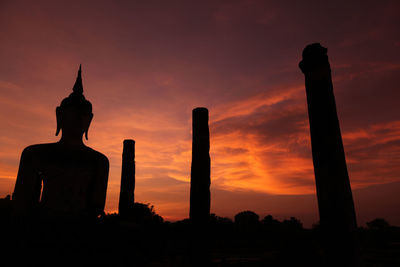 Silhouette statue against sky during sunset