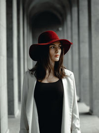 Beautiful young woman looking away while standing against blurred background