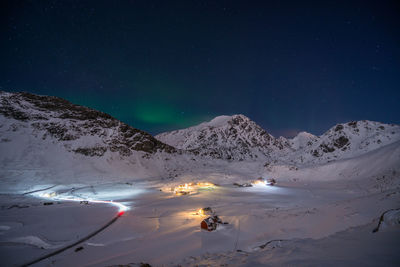 Scenic view of snowcapped mountains against sky at night