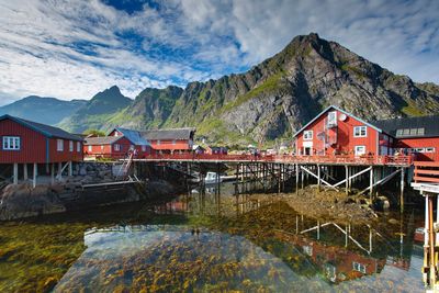 Stilt houses over lake against mountain