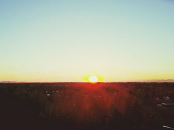 Scenic view of field against clear sky during sunset