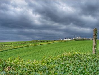 Scenic view of field against cloudy sky