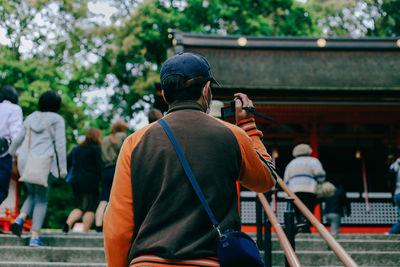 Rear view of man looking at camera