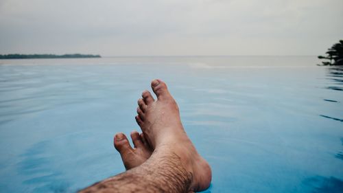 Midsection of person in sea against sky