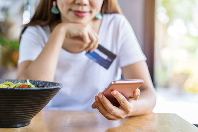 Midsection of woman using mobile phone