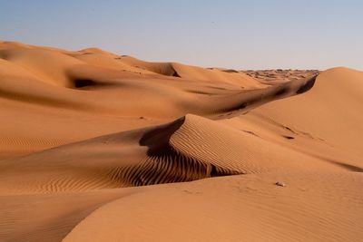 Sand dunes in desert against clear sky