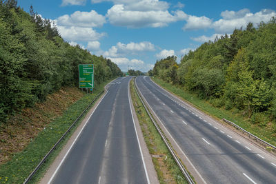 Road amidst trees against sky
